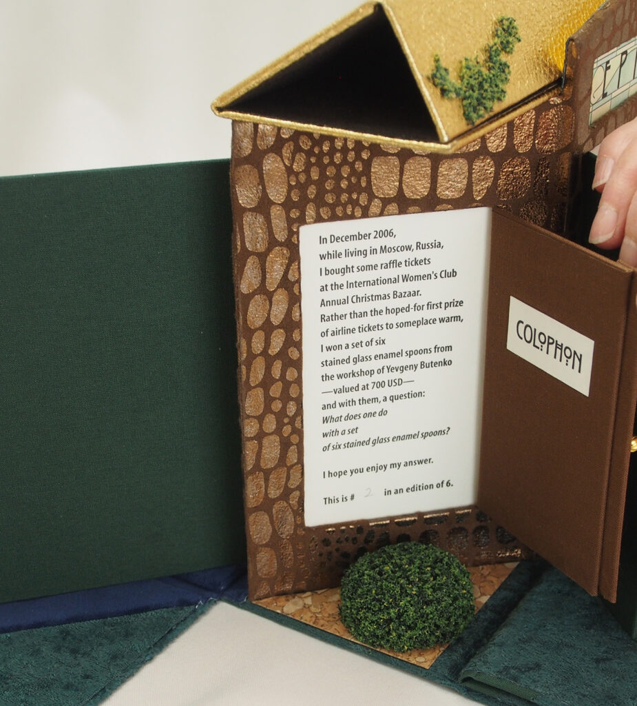 Raffle ticket announcement in a handcrafted book, featuring a textured cover and a small decorative bush. Highlights a unique prize from a Moscow bazaar.